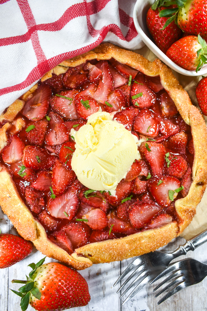 A strawberry galette with a scoop of vanilla ice cream on top