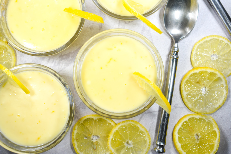 Dishes of lemon posset, lemon slices, and a spoon