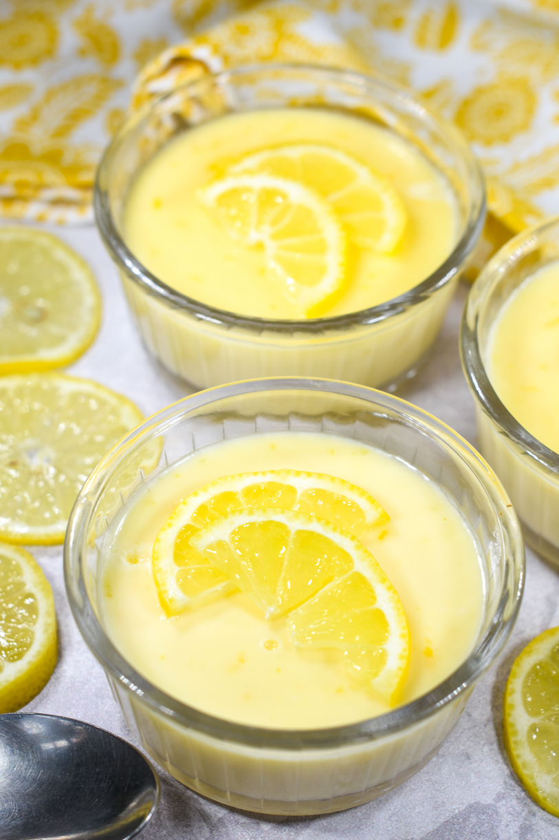 Lemon posset dessert in clear ramekins, garnished with lemon slices