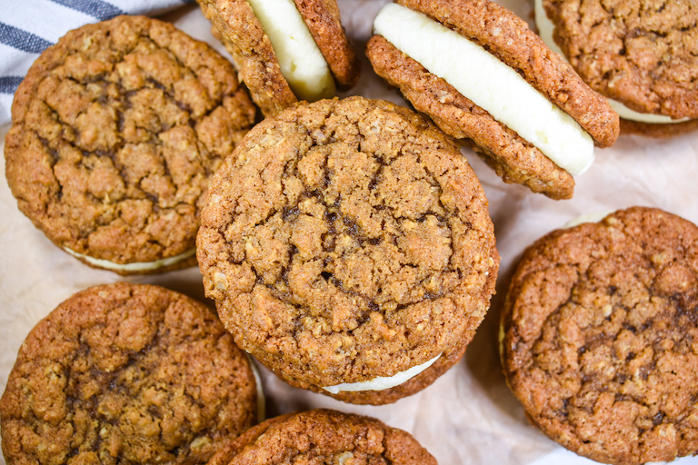 Oatmeal creme pies arranged on a sheet of brown baking parchment