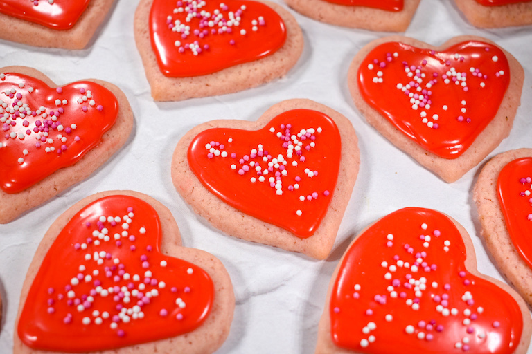 Valentine cookies shaped like hearts, arranged on a white surface