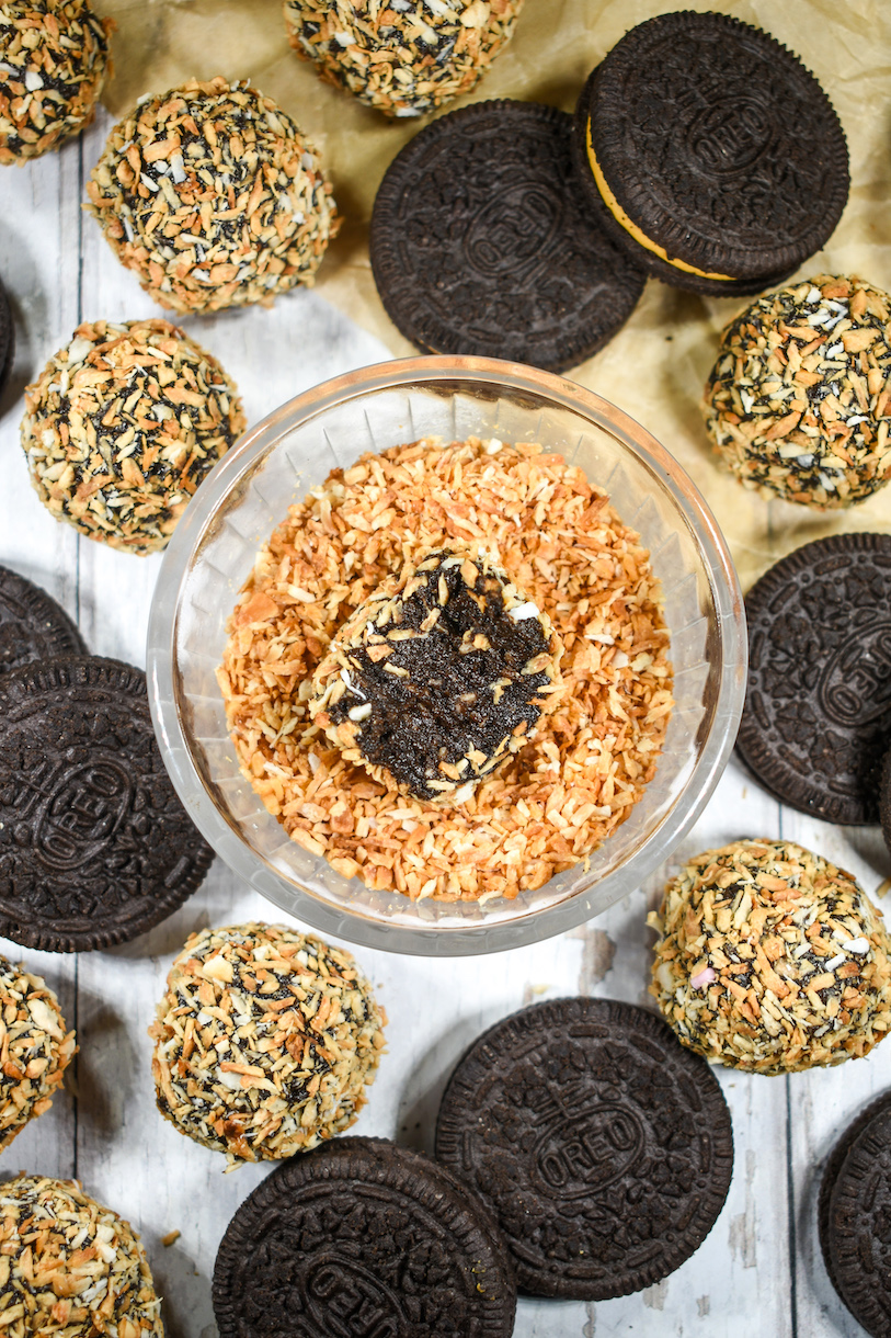 a bowl of toasted coconut surrounded by truffles and Oreo cookies