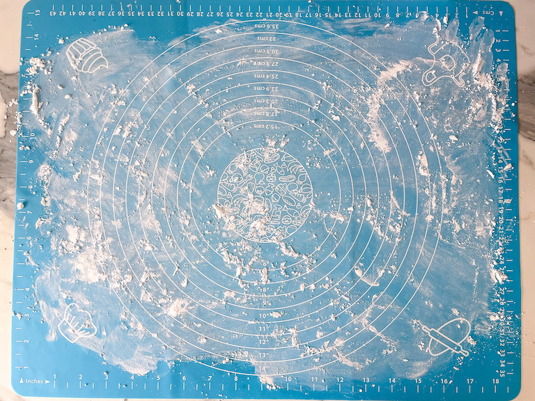 A dusting of confectioner's sugar on a blue rolling mat