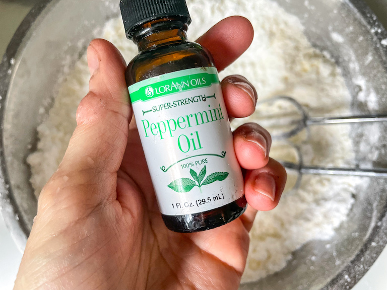 Hand holding a bottle of peppermint oil