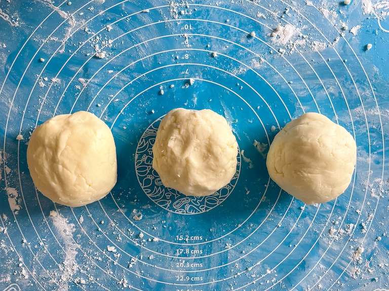 Three balls of buttermint dough on a rolling mat