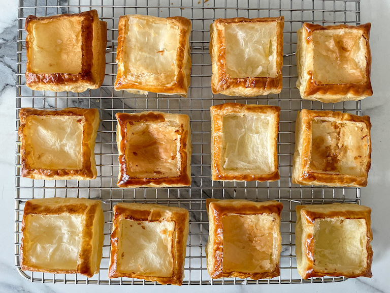 Puff pastry tart shells arranged on a wire rack