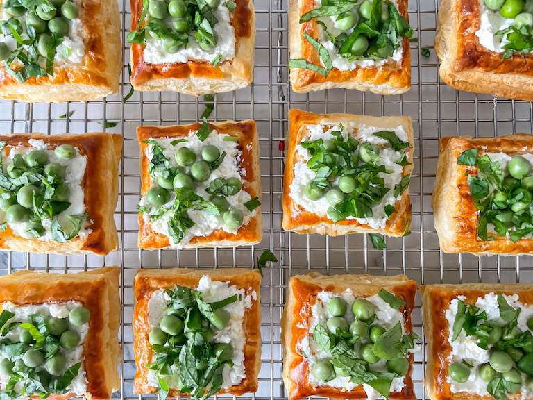 Puff pastry tarts with fresh green herbs sprinkled on top