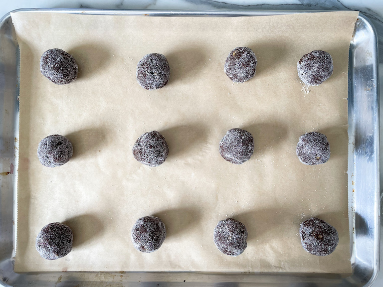 Balls of cookie dough on a parchment lined tray