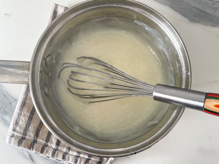 Whisk in saucepan with pudding mixture