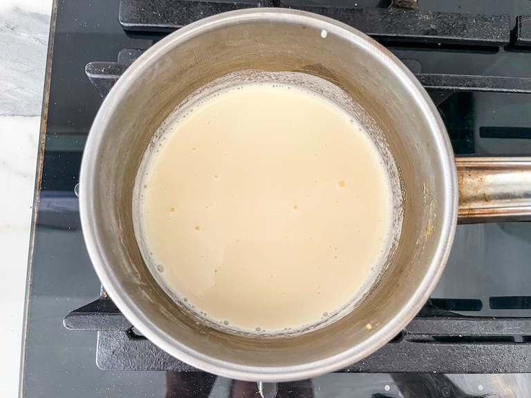 A saucepan of cream on a stovetop
