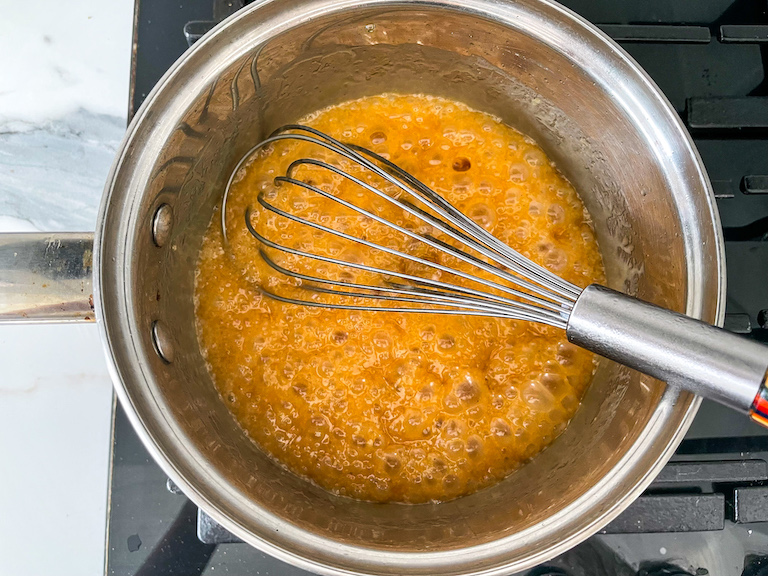 Bubbling caramel in a pan with a whisk