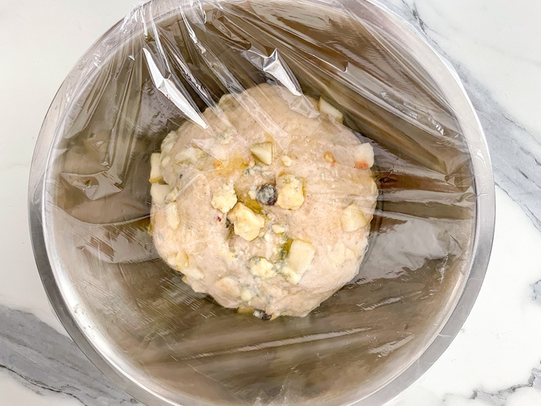 Pear bread dough in a bowl covered in clingfilm