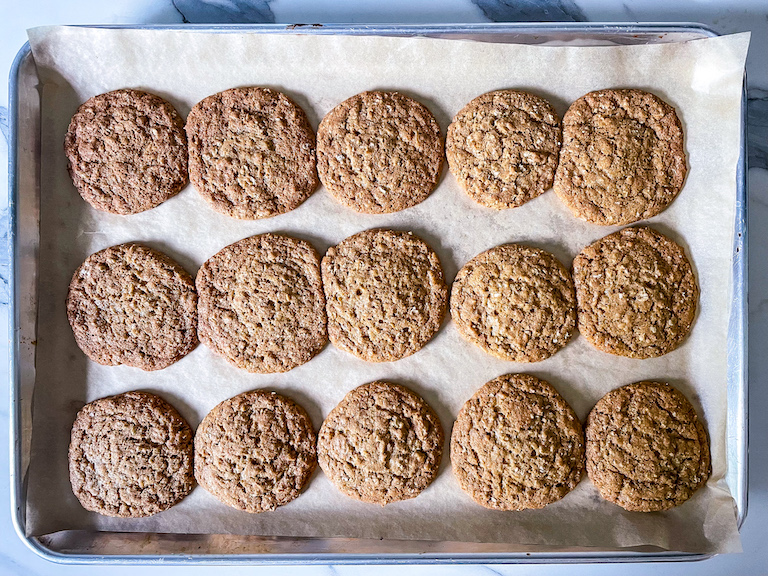 Baked oatmeal cookies on a parchment lined tray
