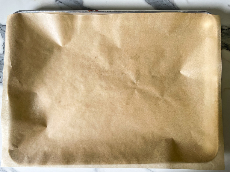 A metal tray with a sheet of parchment paper on top