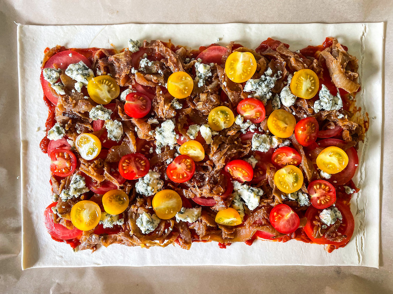 Cherry tomatoes arranged on top of rectangle of puff pastry
