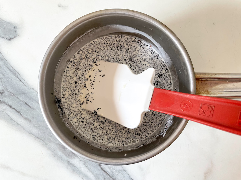 A small saucepan with cream and Earl Grey tea, and a spatula