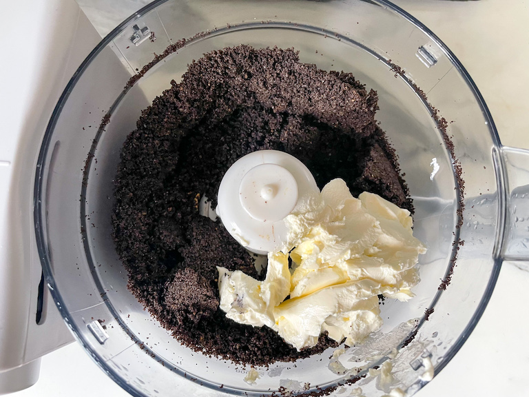 Oreo crumbs and cream cheese in a food processor