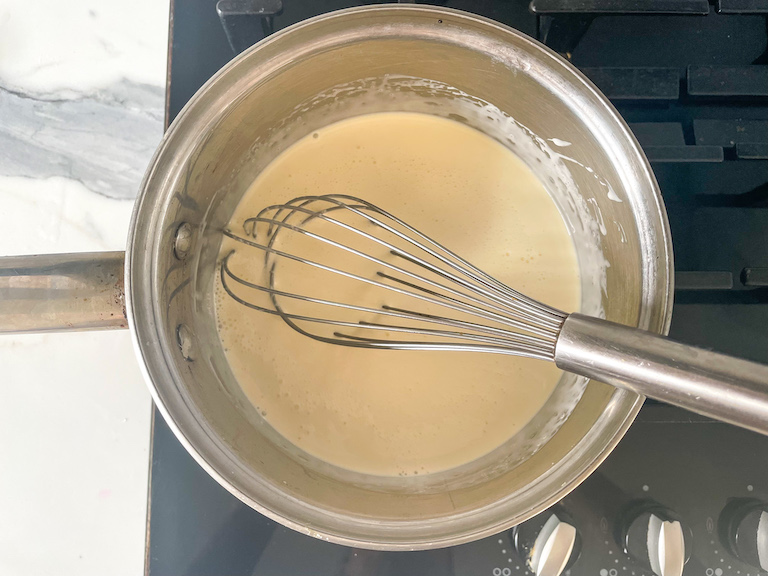 Lemon posset mixture on stovetop with whisk