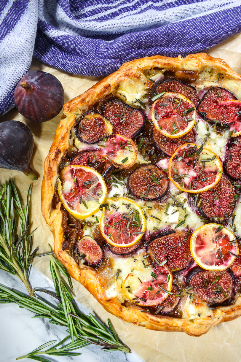 Fig tart with fresh figs, rosemary sprigs, and a purple striped towel