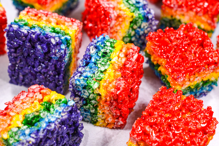 Rainbow crispy treats on a white surface