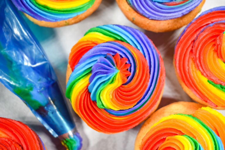 A cupcake with rainbow frosting swirls