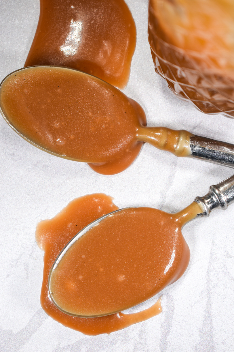 Two spoons covered in homemade salted caramel sauce