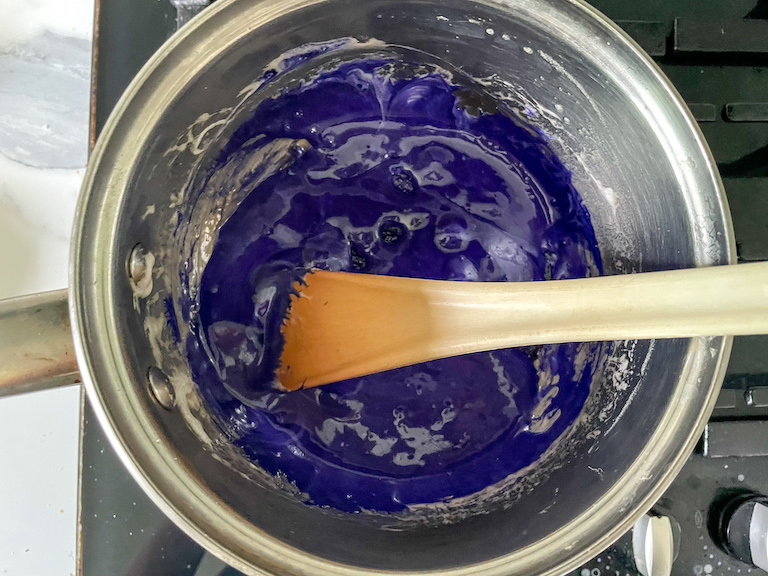 Purple marshmallow mixture in a pan with a spoon