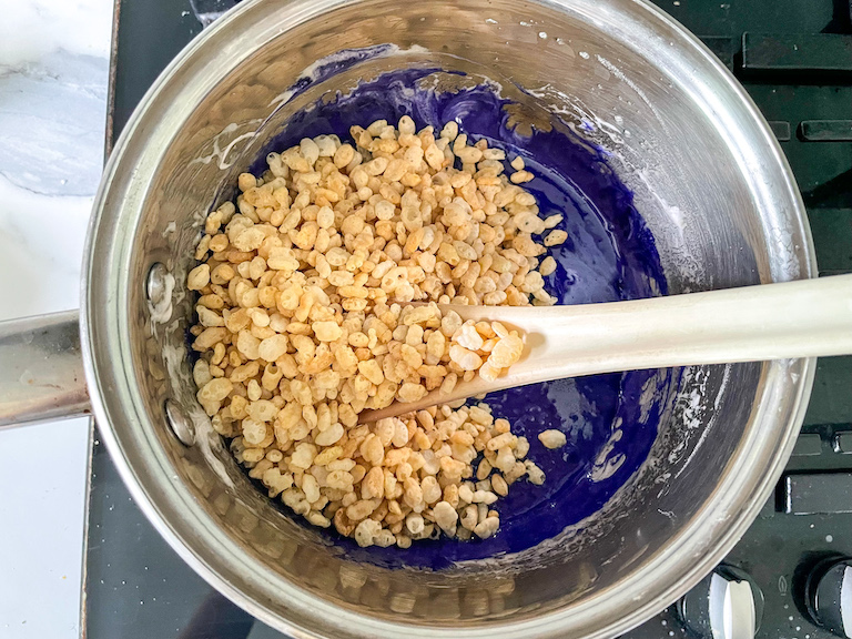Rice krispies and purple marshmallow in a pan