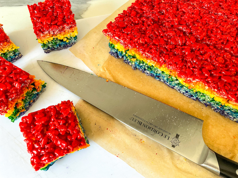 Slicing rainbow rice krispie treats with a knife