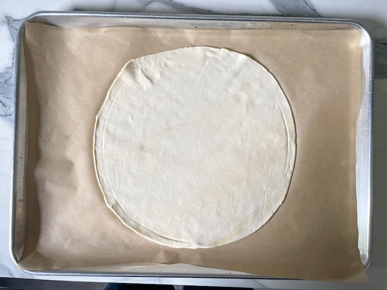 Circle of puff pastry on a sheet of parchment