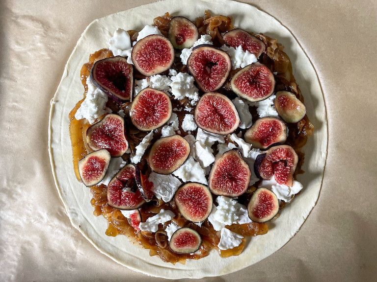 fig slices arranged on top of unbaked puff pastry tart