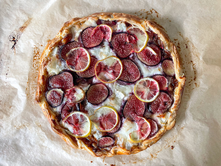 Caramelized onion, fig, and goat's cheese tart on a sheet of parchment