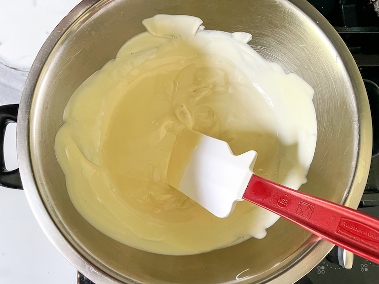 A bowl of melted white chocolate and a spatula