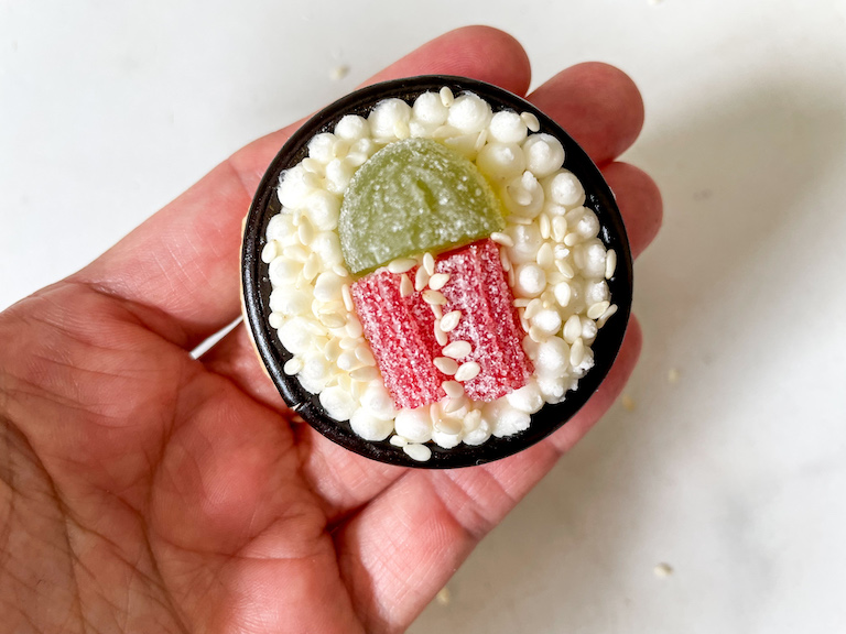 Hand holding a decorated sushi sugar cookie