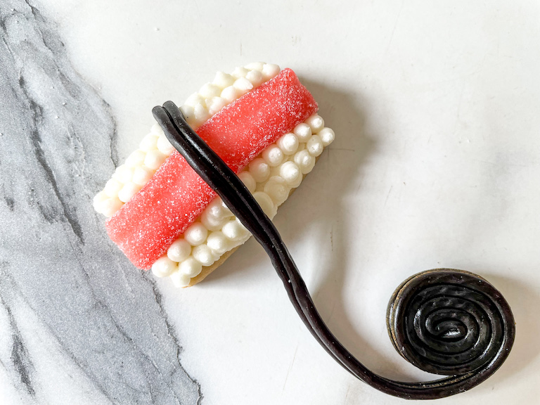 A licorice wheel next to a sushi cookie