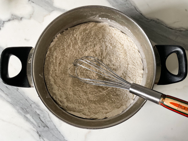 Flour in a stock pot with a whisk