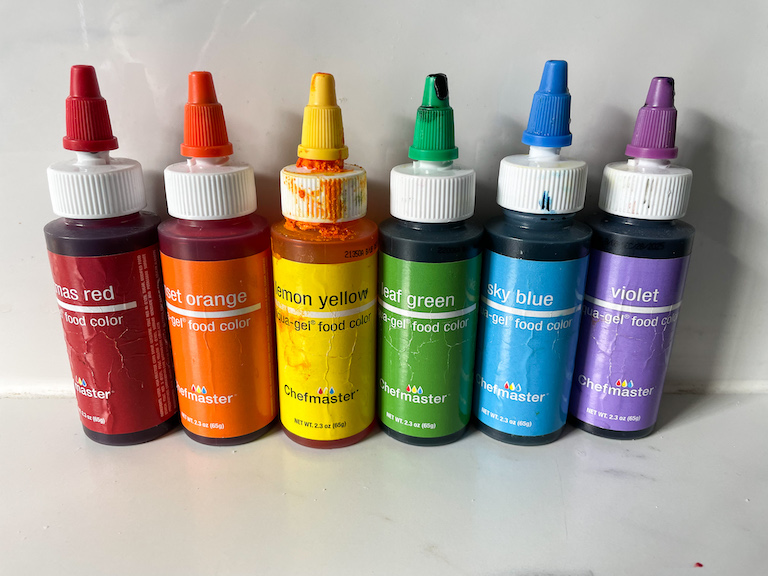 A row of bottles of rainbow gel food coloring