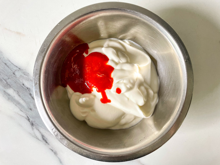 A bowl with yogurt and sriracha