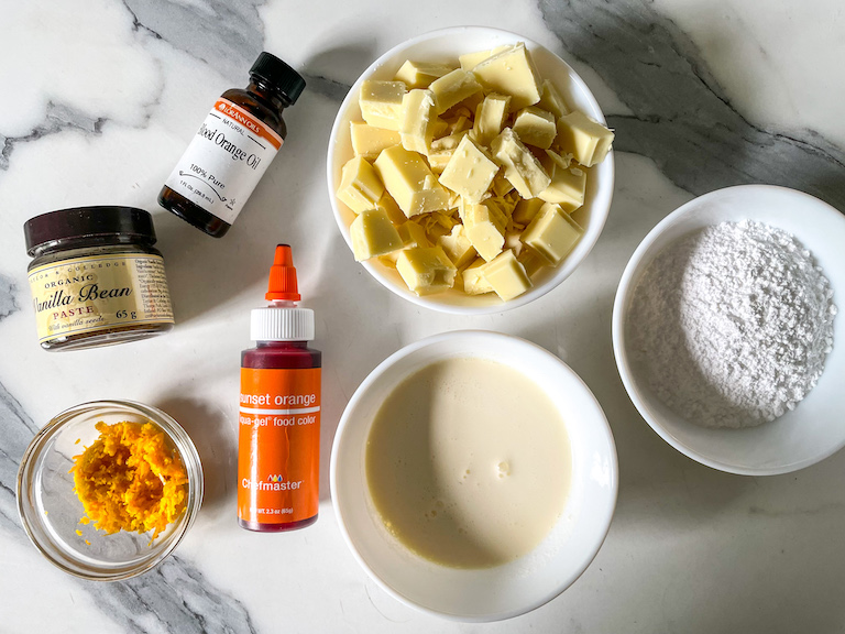 Ingredients for orange truffles arranged on a marble countertop