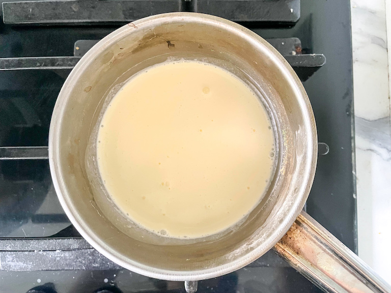 A saucepan of cream on a stovetop