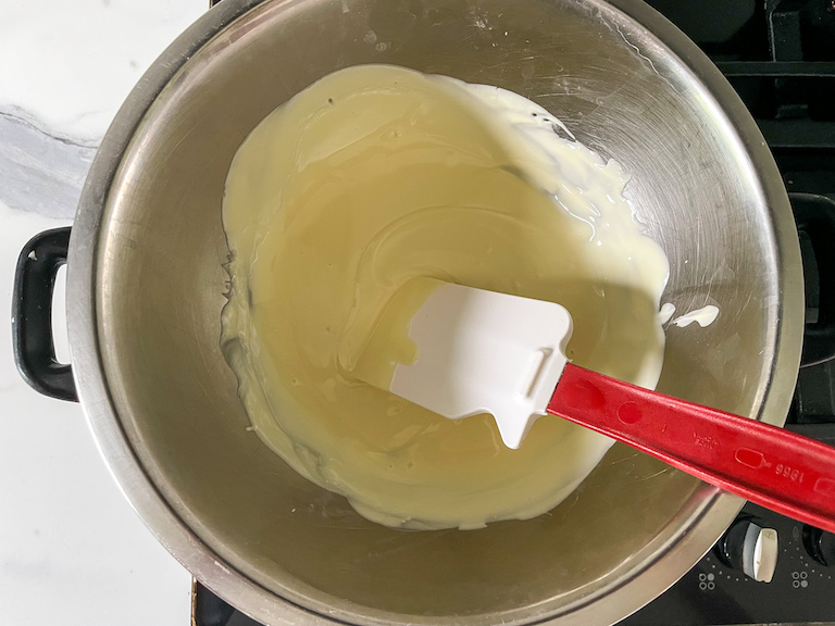 Melted white chocolate in a bowl with a spatula