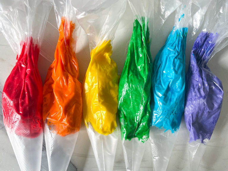 piping bags of rainbow buttercream