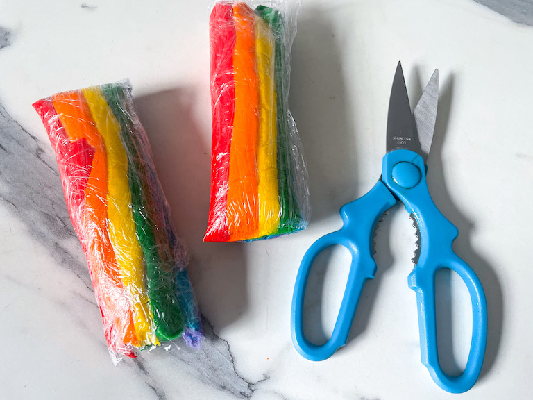 scissors and a cut tube of rainbow frosting