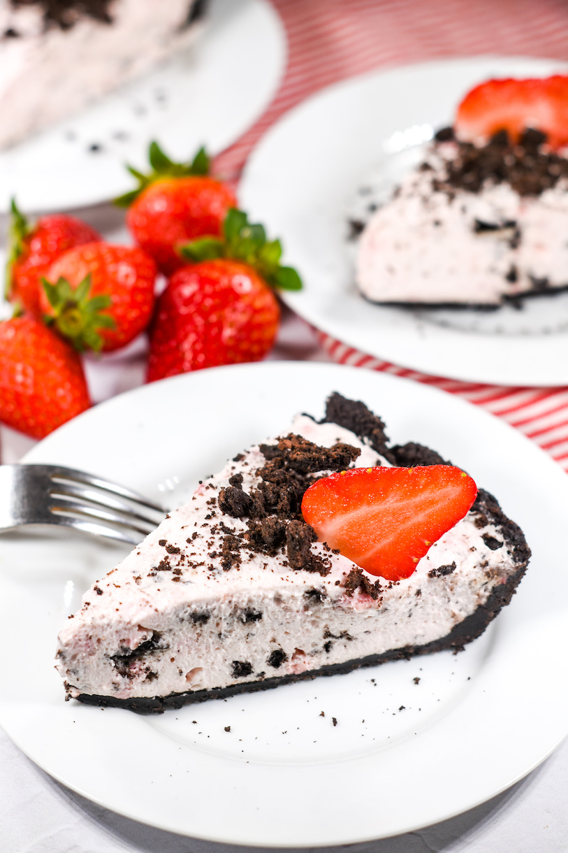 Slice of no bake Oreo pie garnished with a fresh red strawberry