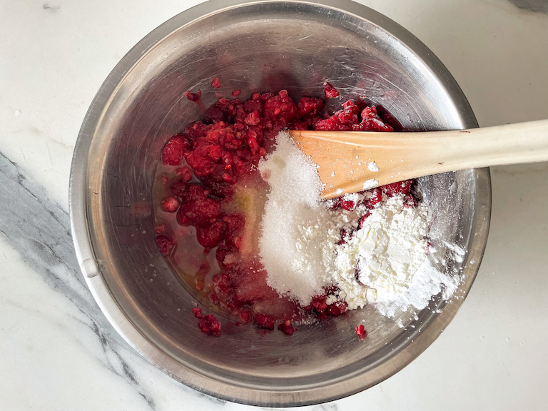 Spoon, berries, flour, and cornstarch in a bowl