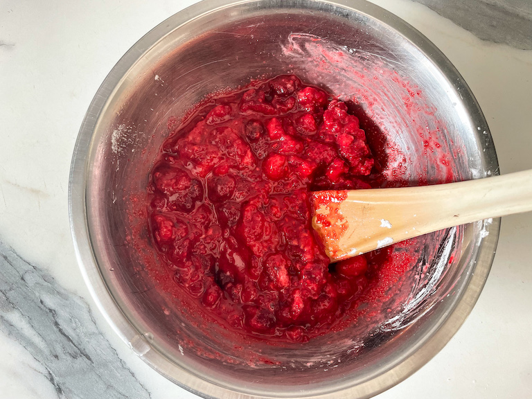 Raspberry mixture and a spoon in a bowl
