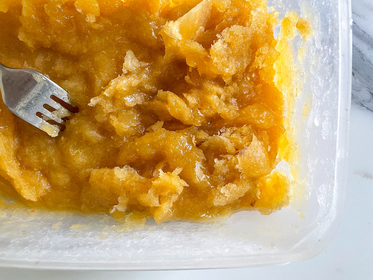 A fork scraping peach granita mixture