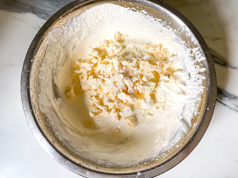 Whipped cream and crushed meringue in a bowl