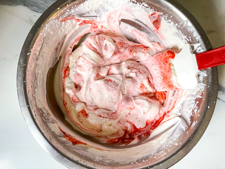 Strawberry sauce in a bowl of whipped cream
