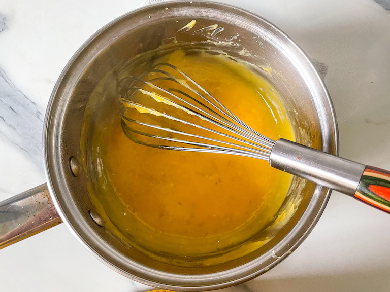 Lime curd in a saucepan with a whisk
